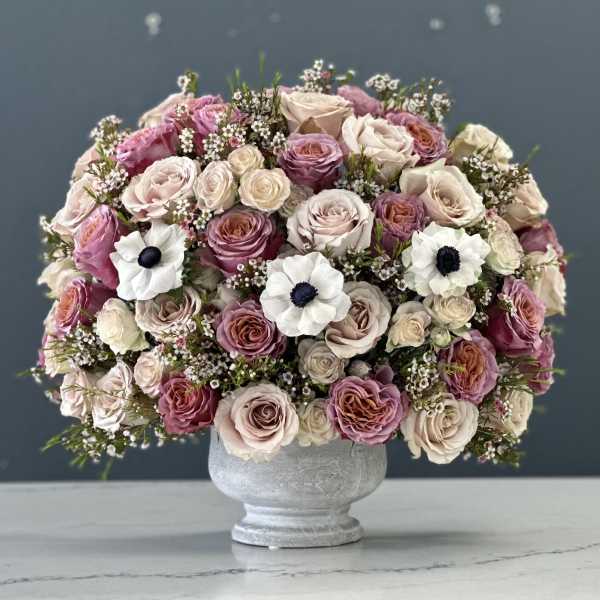 Pink and cream rose bouquet in a gray vase