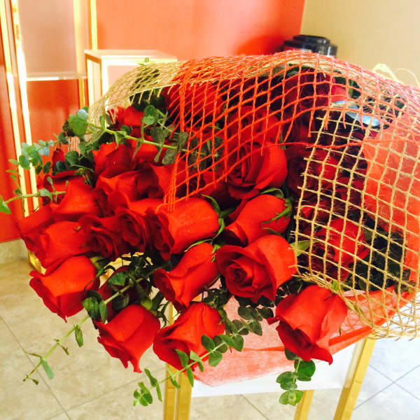 Bouquet of red roses wrapped in orange mesh
