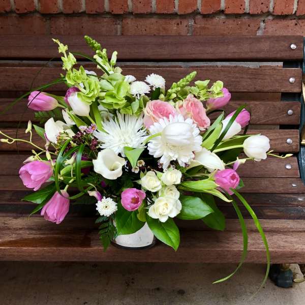 Pink and white mixed flower arrangement in a white vase