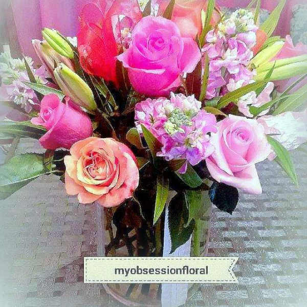 Bouquet of pink and peach roses with lilies in a glass vase