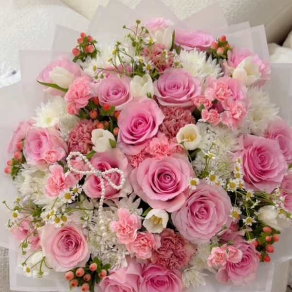 Pink rose bouquet with white accent flowers and paper wrap