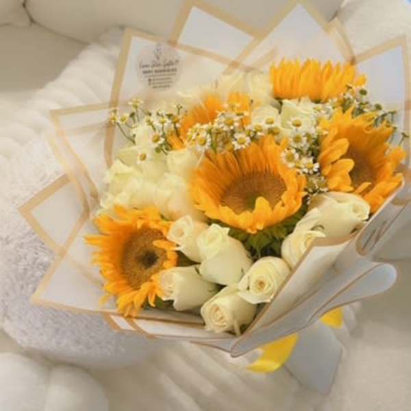 Bouquet of sunflowers and white roses wrapped in cream paper