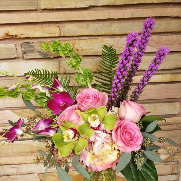 Pink roses and orchids in a glass vase