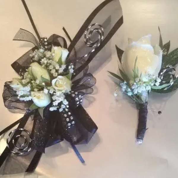 White rose corsage and boutonniere with black ribbon, rhinestones, and small white filler flowers