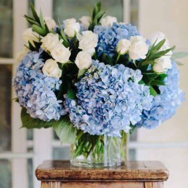 Blue hydrangeas and white roses in a glass vase