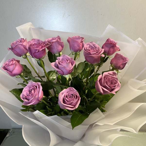 Bouquet of lavender roses wrapped in white paper