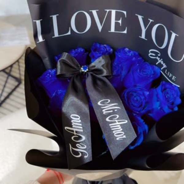 Bouquet of blue roses wrapped in black paper with a ribbon