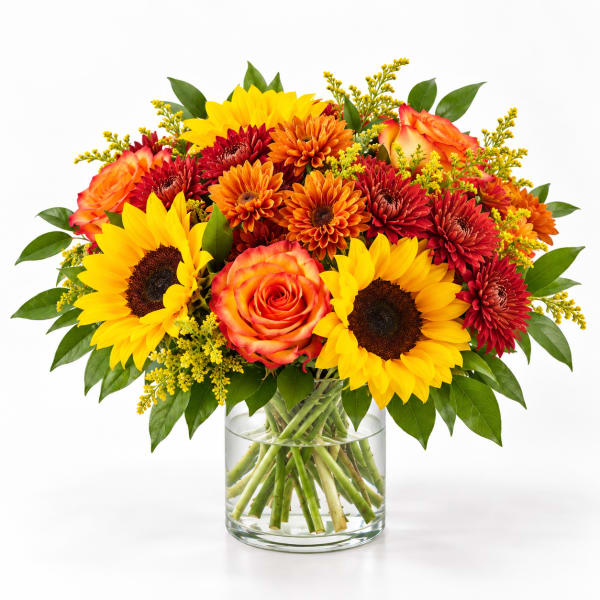 Bouquet of sunflowers, roses, and mums in a clear glass vase