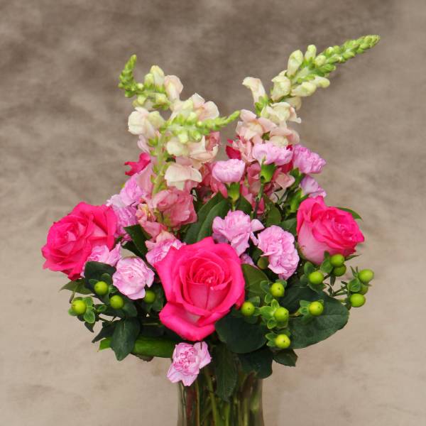 Pink roses and carnations in a clear glass vase