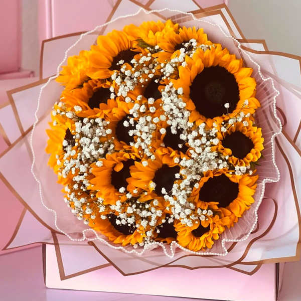 Bouquet of sunflowers with baby's breath in pink wrapping