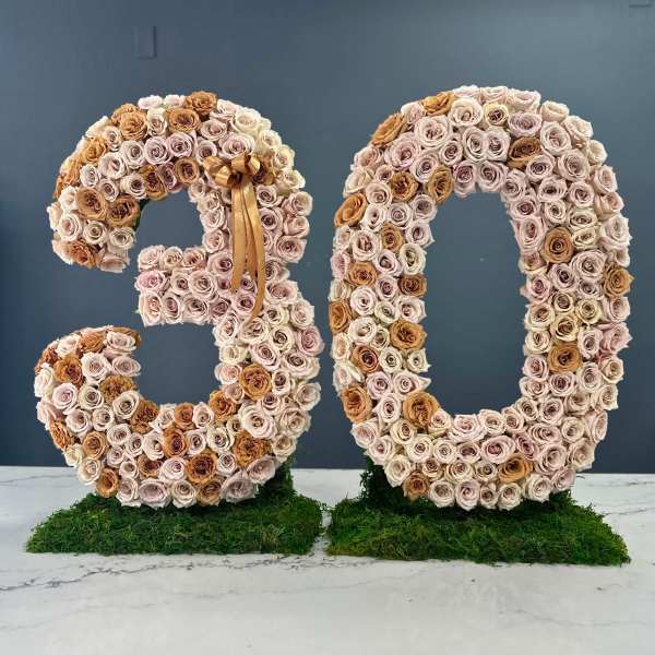 Two large floral number sculptures made of roses, shaped as 3 and 0.