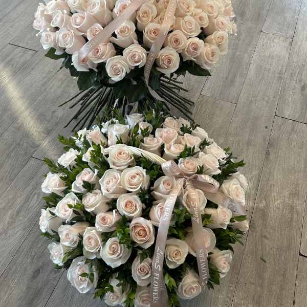 Two large bouquets of pale pink roses with ribbon ties