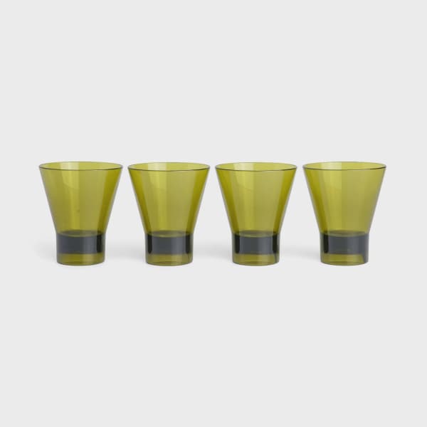 Four yellow-green drinking glasses on a white background