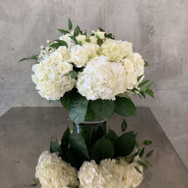 White hydrangea and rose arrangement in a glass vase