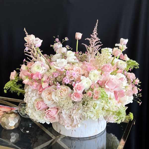 Large pastel floral arrangement in a white round box