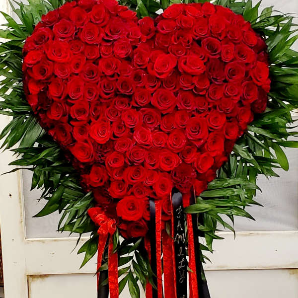 Heart-shaped red rose standing spray with red and black ribbons