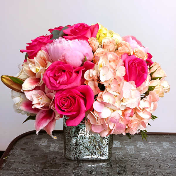 Pink roses and peach hydrangeas in a square silver vase