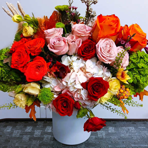Mixed roses and hydrangeas arranged in a white vase