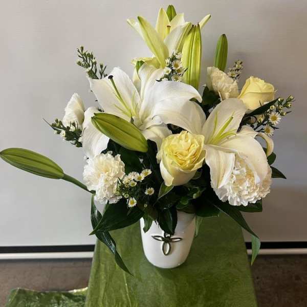 White lilies and pale yellow roses in a white vase