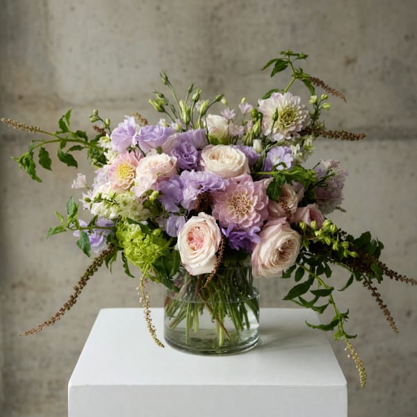 Pastel bouquet of roses and mixed blooms in a clear glass vase