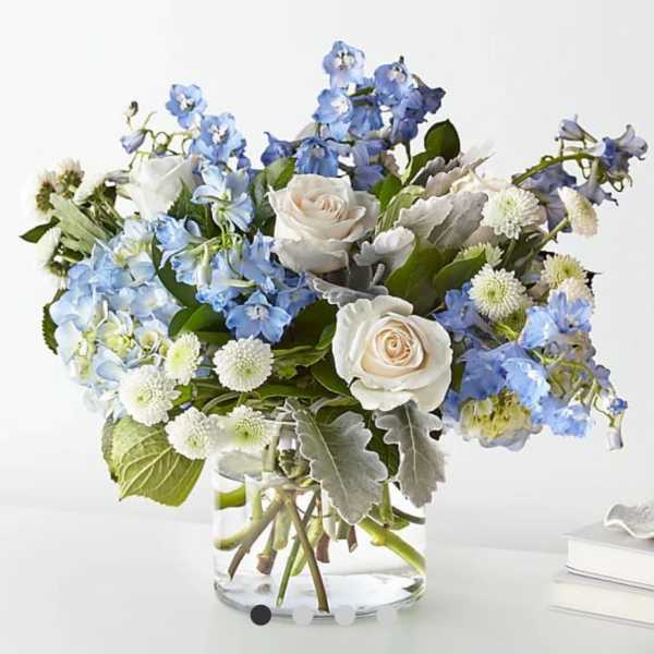 Blue and white flowers arranged in a clear glass vase