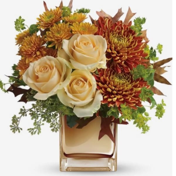 Cream roses and autumn mums in a square glass vase