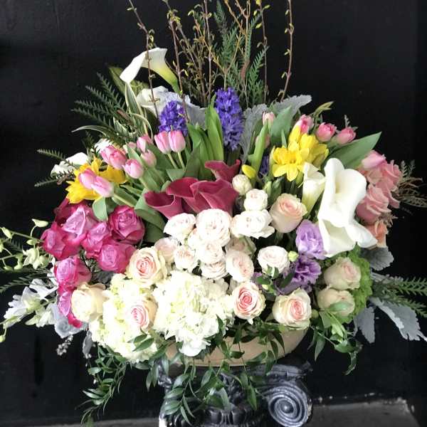 Large mixed bouquet with pink, white, yellow, and purple flowers in a vase