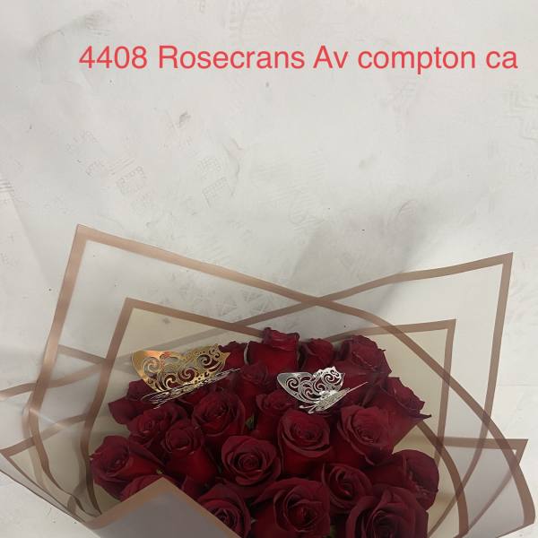 Bouquet of red roses wrapped in clear paper with a pink ribbon