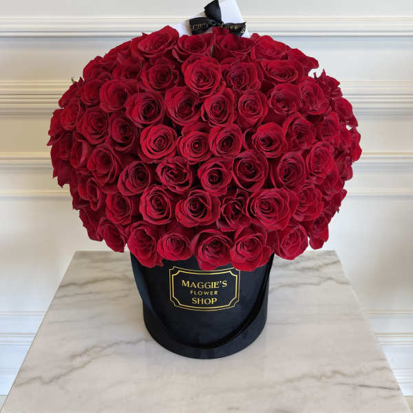 Large bouquet of red roses in a black hatbox