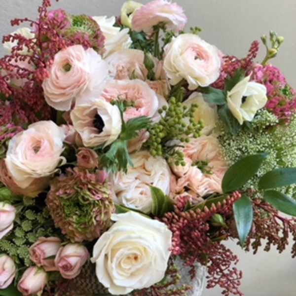Bouquet of pale pink and white flowers with green accents