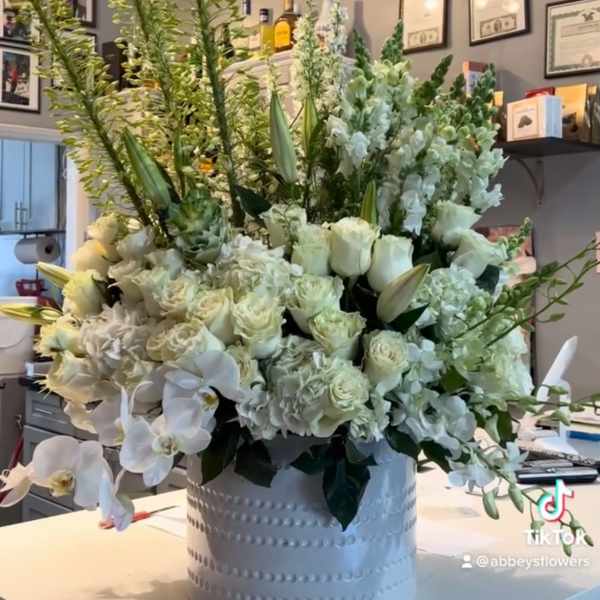 Large white floral arrangement in a round white container