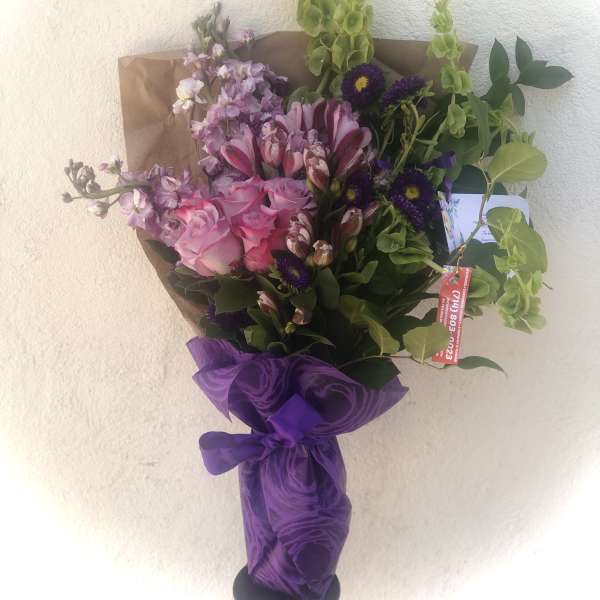 Bouquet of pink and purple flowers wrapped in purple paper