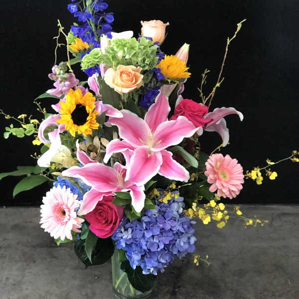 Colorful mixed flower arrangement in a clear glass vase