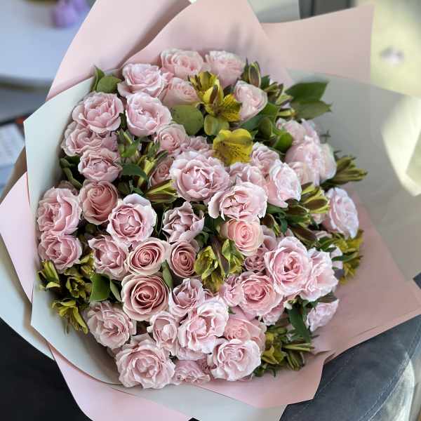 Bouquet of pale pink roses and yellow alstroemeria wrapped in pink paper