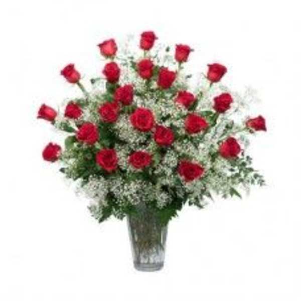 Red roses in a clear glass vase with white filler flowers