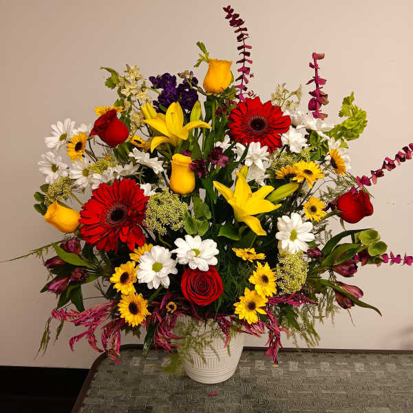Colorful mixed flower arrangement in a white vase