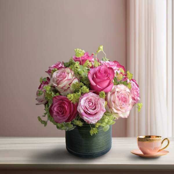 Pink and white roses arranged in a dark green vase