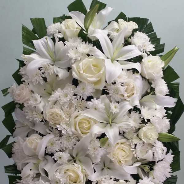 Large white floral standing spray with lilies and roses
