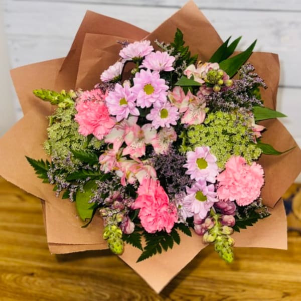 Pink and lavender mixed bouquet wrapped in brown paper