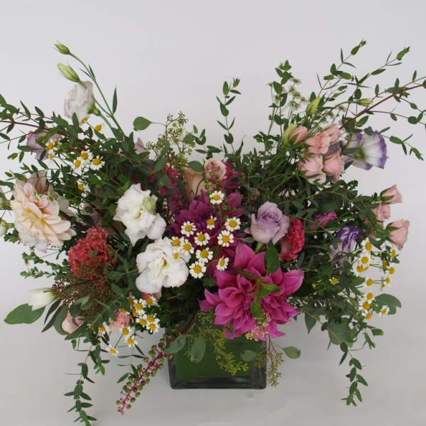 Mixed floral arrangement in a black vase with pink, white, and purple blooms