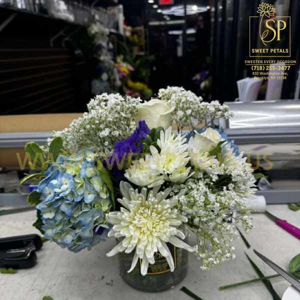 Bouquet of white and blue flowers in a small vase