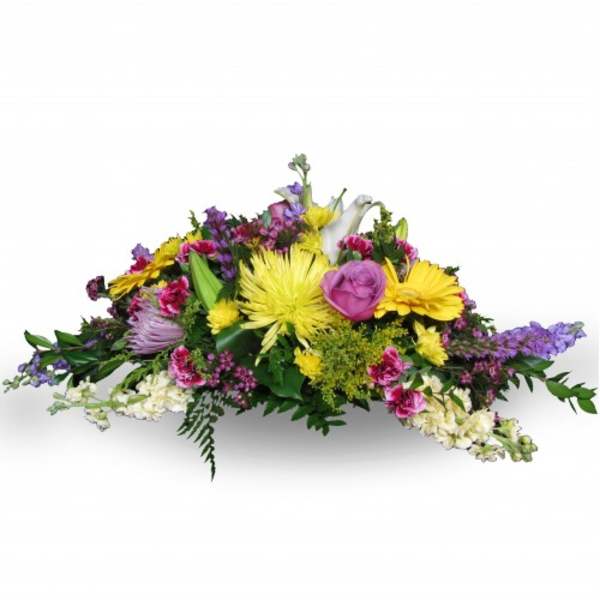 Low floral arrangement with yellow, pink, purple, and white blooms