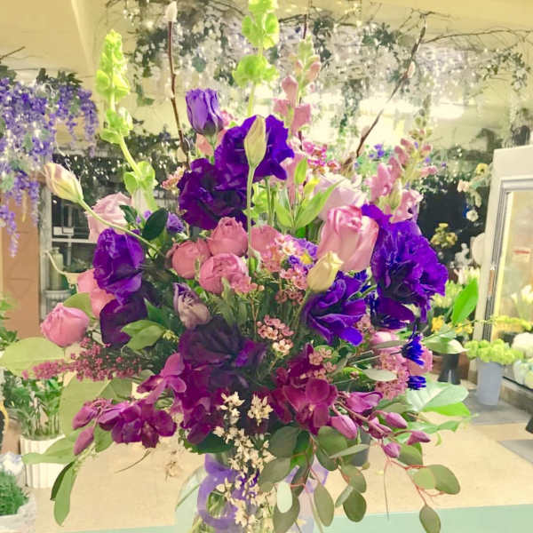 Tall bouquet of pink and purple flowers in a clear vase