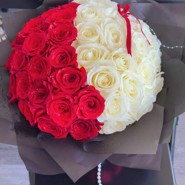 Red and white rose bouquet wrapped in dark paper