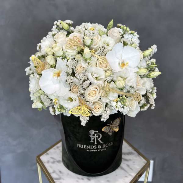 White and cream bouquet in a black hat box with gold butterfly accents
