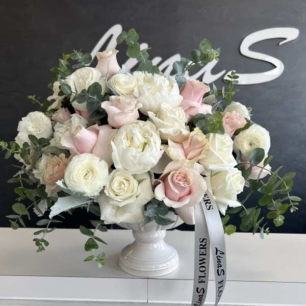 Pink and white rose bouquet in a white pedestal vase