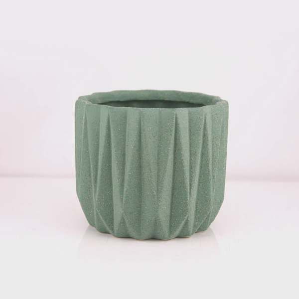 Green textured ceramic planter pot on a white background