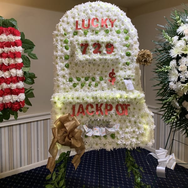 Large white floral display shaped like a slot machine with red lettering