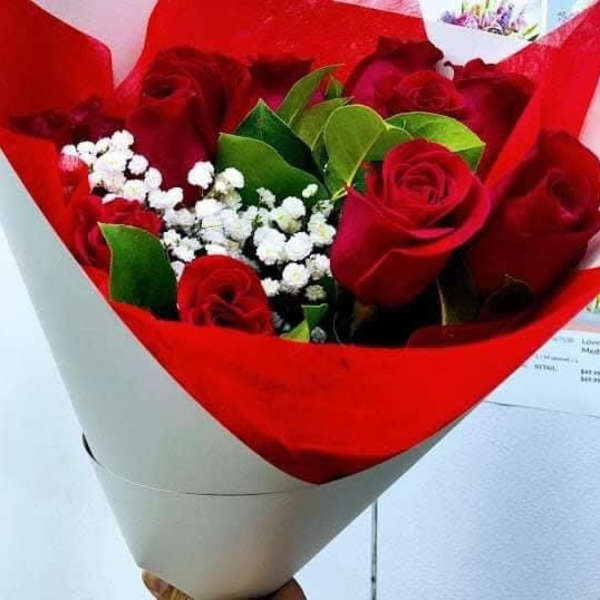 Bouquet of red roses with white baby's breath in red and white wrap