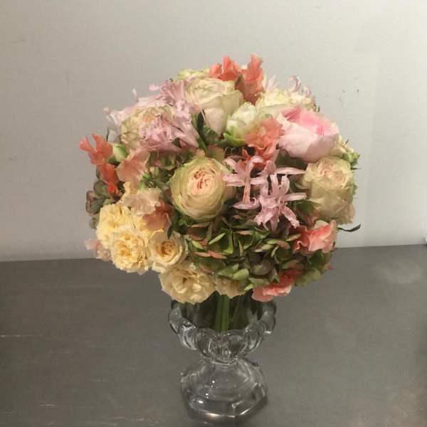 Pastel bouquet of roses and mixed blooms in a clear glass vase